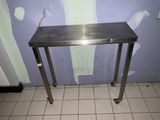 une table en acier inoxydable au milieu d'un sol carrelé