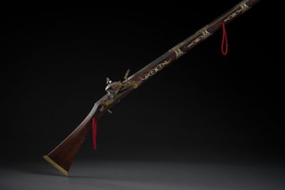 an old rifle with a wooden handle on a black background