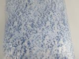 a blue and white pillow on a white surface