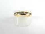 gros plan d'une bague en or avec des diamants sur une surface blanche