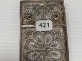 a small silver cigarette case with a number on it
