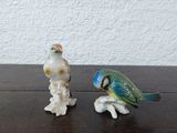 deux figurines d'oiseaux posées sur une table en bois