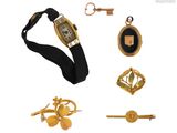 une photo présentant une collection de bijoux comprenant une montre, une clé et d'autres objets