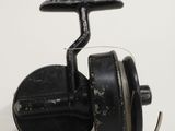 a black spinning reel on a white surface