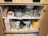a cabinet with dishes and cups on it in the kitchen