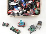 une boîte remplie de petites voitures de toutes sortes posée sur une surface blanche