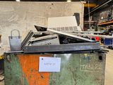 une grande caisse métallique sur laquelle est posé un ordinateur portable, dans un entrepôt