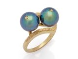 un gros plan d'une bague ornée de deux perles bleues
