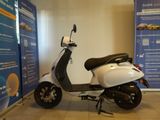 a motor scooter parked in front of a blue and white banner