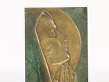 statue of a woman with a praying hand on a green background