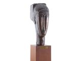 une image représentant une sculpture représentant une tête de femme posée sur un socle en bois