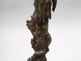 a bronze statue of a bird perched on a tree stump