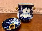 a blue and white vase sitting on a table next to a bowl