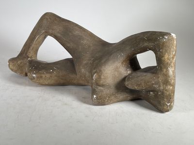 sculpture représentant une femme allongée sur le dos sur une surface blanche