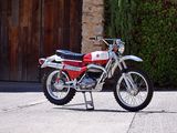 a red and white dirt bike parked in front of a building