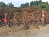 une rangée de vieux outils agricoles posés par terre