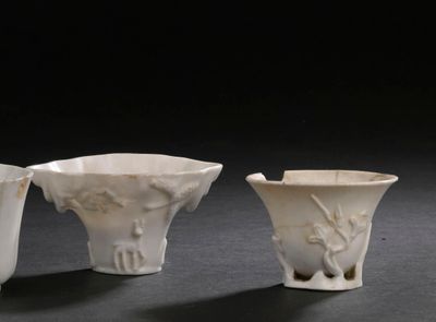 trois vases blancs posés les uns à côté des autres sur une table
