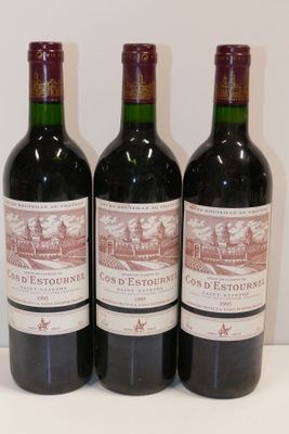 trois bouteilles de vin rouge sont alignées sur une table