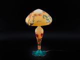 une lampe de table en verre surmontée d'un abat-jour jaune