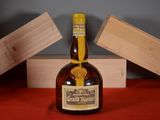 a bottle of liquor sitting on a table next to a wooden box