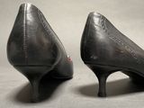 pair of black high heeled shoes on a gray surface