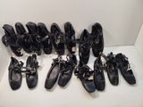 Plusieurs paires de chaussures noires sont alignées sur une étagère blanche