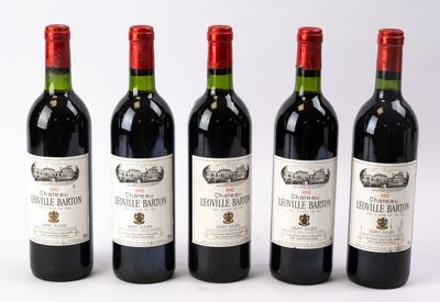 quatre bouteilles de vin sont alignées sur une surface blanche