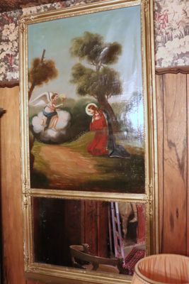 a painting on the wall above a mirror in a room