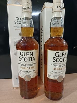 deux bouteilles de whisky Glen posées sur une table à côté d'une boîte