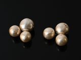 deux paires de perles reposent sur une surface noire