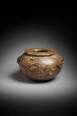 a brown vase sitting on top of a table next to a black background