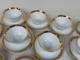 many cups and saucers sitting on a white table