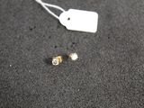 a tag and a pair of earrings on a table