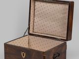a small wooden box that is open on a gray surface