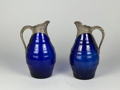 une paire de vases en verre bleu avec des anses en argent sur fond blanc