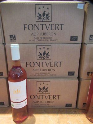 des bouteilles de vin posées sur une table en bois, à côté de cartons de vin