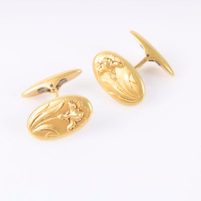 an image of a pair of gold cufflinks on a white background