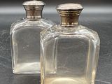 deux bouteilles en verre transparent avec des bouchons argentés posées sur une table