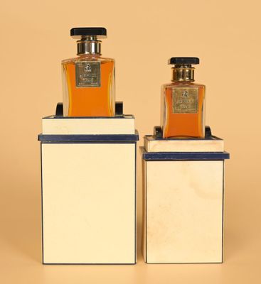 two bottles of perfume sitting on top of each other on display