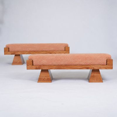 two wooden benches with orange cushions on them against a white background