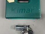 a green case with a revolver and two keys on a table