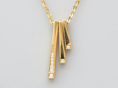 gros plan d'un collier en or sur une surface blanche
