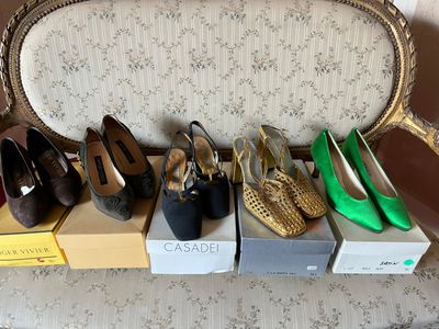 several pairs of women ' s shoes are lined up on a bench