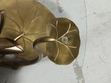 a gold plate with a leaf and a flower on it