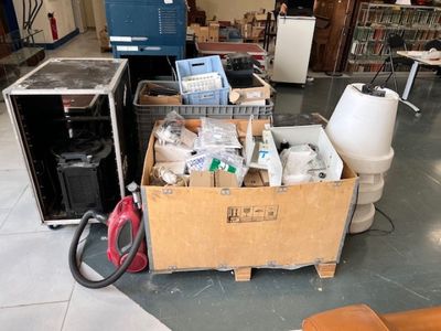 une boîte remplie d'objets posée par terre dans une pièce