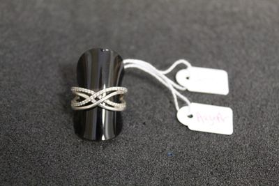 une bague posée sur une table, avec une étiquette indiquant son prix