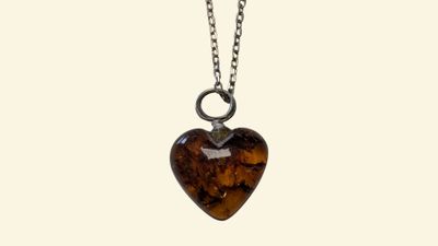 a close up of a heart shaped pendant on a chain