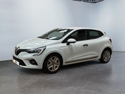 Une voiture blanche est garée dans une pièce blanche au sol noir.