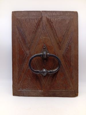 une image représentant une boîte en bois surmontée d'un anneau métallique