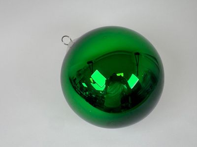 une décoration de Noël verte accrochée à une table blanche